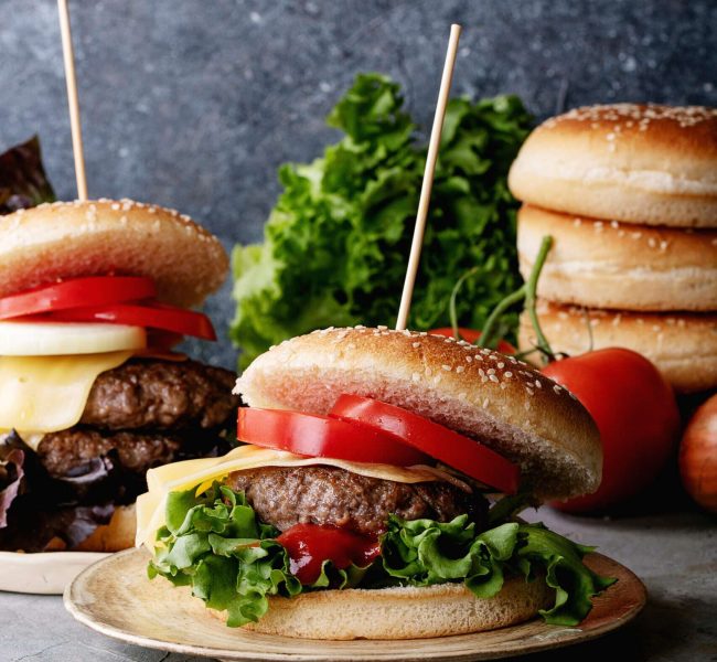 Homemade hamburger with fresh vegetables: lettuce, onions, tomato and ketchup